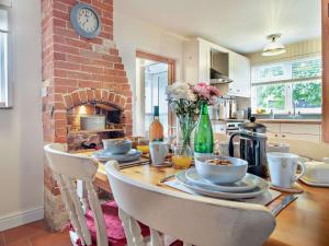 a kitchen with a table with chairs and a brick fireplace at 2 Bed in Stowmarket 37011 in Stowmarket