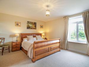1 dormitorio con cama de madera y ventana en 2 Bed in Stowmarket 37011 en Stowmarket