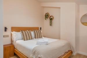 1 dormitorio con 1 cama con sábanas y almohadas blancas en Marconia Boutique Residence, en L'Estartit