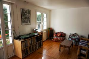 a living room with a book shelf and a chair at JOYU SURF SHACK in Bidart