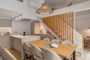 comedor y cocina con mesa y sillas en Marconia Boutique Residence, en L'Estartit