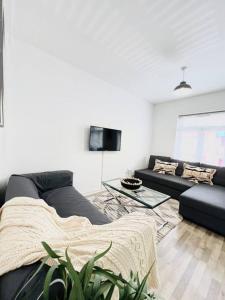 a living room with a couch and a table at 2 Bed Apartment next to Finsbury Park Station! (C) in London