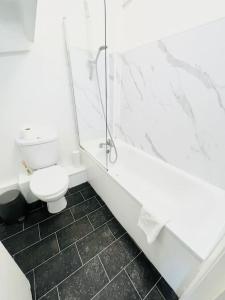 a white bathroom with a shower and a toilet at 2 Bed Apartment next to Finsbury Park Station! (C) in London