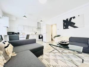 a living room with a couch and a table at 2 Bed Apartment next to Finsbury Park Station! (C) in London