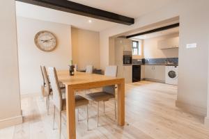 uma cozinha e sala de jantar com uma mesa de madeira e cadeiras em Newly renovated 3 bed Tarvin home -sleeps up to 11 em Tarvin