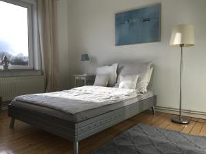 a bed in a bedroom with a lamp and a window at Gr Wohnung mit 3 sep Schlafzimmern in Bremen