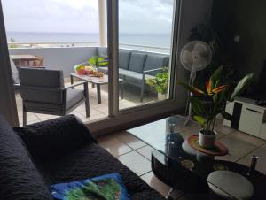 una sala de estar con un sofá y una mesa en Ty Kaz Dodo, en Saint-Gilles-les-Bains