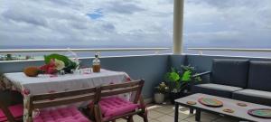 a table with pink cushioned chairs and a table on a ship at Ty Kaz Dodo in Saint-Gilles-les-Bains