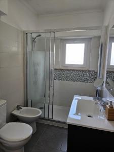 een badkamer met een douche, een toilet en een wastafel bij Bolina 2 Historic Center Cascais in Cascais