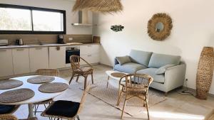 a living room with a couch and a table and chairs at Villa Copains, 5 pers, piscine chauffée, 5 mn plage in Cirendinu