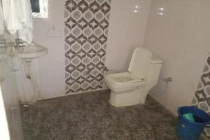 een badkamer met een toilet en een wastafel bij OYO Home Chanakya Palace in Pāli