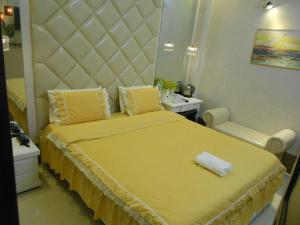a bedroom with a large yellow bed with a large headboard at Thanh Hằng Homestay in Can Tho