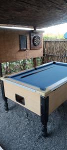 a pool table with a clock on top of it at Pole Pole Beach House in Watamu