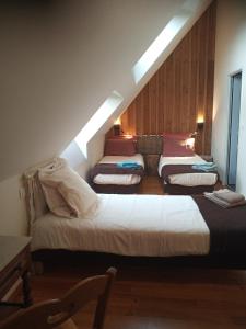 Zimmer im Dachgeschoss mit 4 Betten und einem Sofa in der Unterkunft La grange d'Armand in Mentheville
