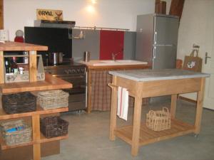 eine Küche mit einem Kühlschrank und einem Tisch darin in der Unterkunft La grange d'Armand in Mentheville