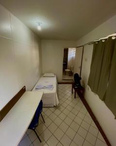 a room with two beds and a table in it at Hotel Rio Center in Juazeiro