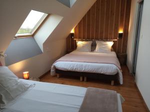 Schlafzimmer im Dachgeschoss mit 2 Betten und einem Fenster in der Unterkunft La grange d'Armand in Mentheville