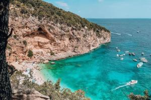 un grupo de personas en el agua en una playa en Flamingo Residence, en Santa Maria Navarrese