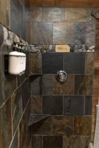 y baño con ducha alicatada y dispensador de jabón. en O'Neill Cabin - a rustic reclaimed retreat, en Index