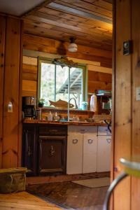 una cocina con fregadero y una ventana en una cabaña en O'Neill Cabin - a rustic reclaimed retreat, en Index