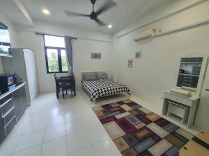 ein Wohnzimmer mit einem Bett und einem Tisch sowie eine Küche in der Unterkunft MyStudio Imperio Home , Alor Setar with sky infinity pool in Alor Setar