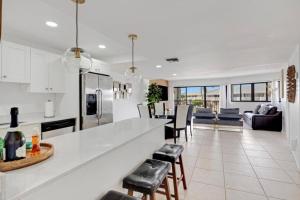 a kitchen and living room with a counter and chairs at Overlooking Marina/Ocean view & FREE GOLF CART in Key Largo