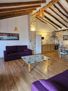 a living room with a purple couch and a table at CASA DEL LLAVADOR Vall de Guadalest in Benifató