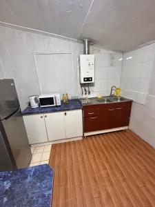 a small kitchen with a sink and a microwave at Casa familiar in Temuco