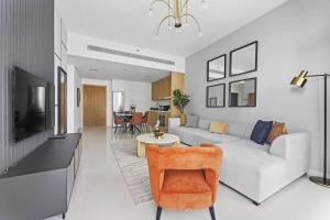 a living room with a white couch and a tv at Silkhaus new 1BDR with Private beach in Dubai