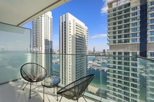 a balcony with two chairs and a view of a city at Silkhaus new 1BDR with Private beach in Dubai