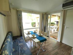 ein kleines Zimmer mit einem Tisch, einem Bett und einem Fenster in der Unterkunft Bungalow charmant à Saint-Chéron avec piscine partagée in Saint-Chéron