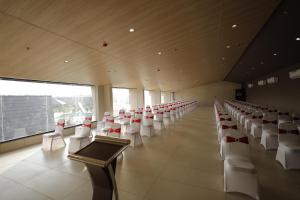 a room with rows of white chairs and a podium at Regenta Resort Vindhyachal, Statue of Unity in Kevadia +59 photos