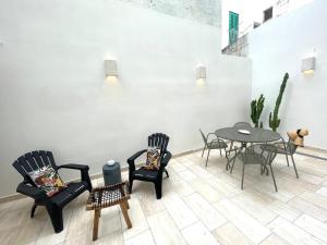 a room with chairs and a table and a table and chairs at CASA RICASOLI by MANZONI COLLECTION in Monopoli