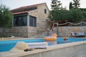 un sombrero y un par de gafas de sol sentadas en una piscina en Villa Broč, en Postira