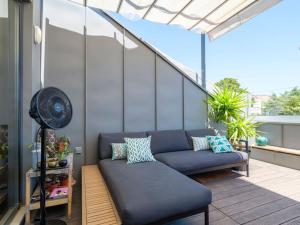 un divano blu su un balcone con ventilatore di Rooftop Terrace Apart With View 4 Bedrooms, 4 Bathrooms and AC a Lisbona