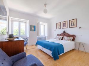 una camera con un letto con una coperta blu e un divano di Rooftop Terrace Apart With View 4 Bedrooms, 4 Bathrooms and AC a Lisbona