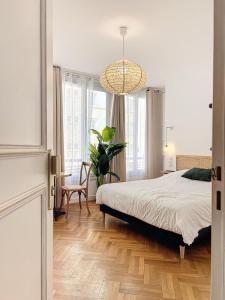 a bedroom with a bed and a chandelier at - - Maison ŪMA - Marseille - - Wifi, Mer et Centre in Marseille