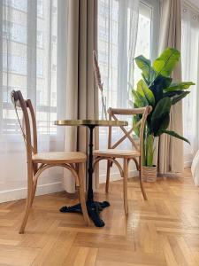 uma mesa e duas cadeiras e uma planta num quarto em - - Maison ŪMA - Marseille - - Wifi, Mer et Centre em Marselha