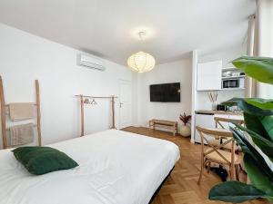 a white bedroom with a bed and a kitchen at - - Maison ŪMA - Marseille - - Wifi, Mer et Centre in Marseille