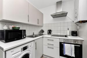 a white kitchen with a microwave and a dishwasher at 1 Bedroom Apartment- Finsbury Park Station (D) in London