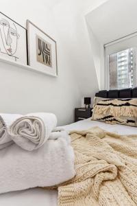 a white bedroom with towels on a bed at 1 Bedroom Apartment- Finsbury Park Station (D) in London