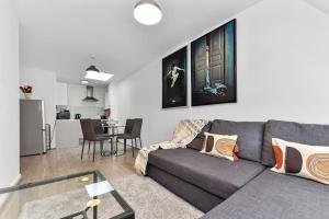 a living room with a gray couch and a kitchen at 1 Bedroom Apartment- Finsbury Park Station (D) in London