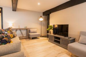 uma sala de estar com um sofá e uma televisão em Newly renovated 3 bed Tarvin home -sleeps up to 11 em Tarvin