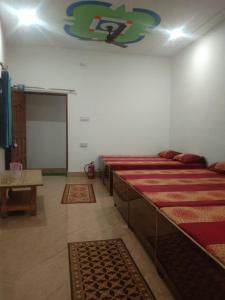 a room with several beds in a room with rugs at Badrinath House by Prithvi Yatra Hotel in Badrīnāth