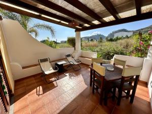 sala de estar con mesa, sillas y sofá en Villa Saraceno en Lipari