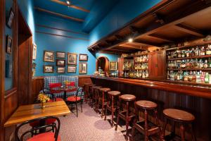 a bar with a row of stools in a restaurant at Hotel Victoria in Cuenca