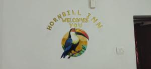 a bird sign on a wall with a welcome to you sign at Hornbill inn in Cochin