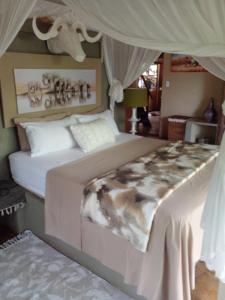 a bedroom with a large bed with a canopy at Canyon guest villa in Hoedspruit