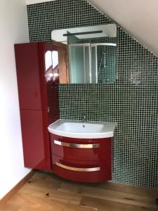 a bathroom with a red sink and a mirror at Les Gelots in Villemurlin +9 photos