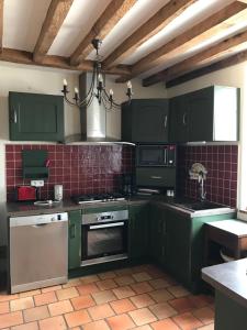 a kitchen with green cabinets and a chandelier at Les Gelots in Villemurlin